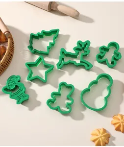 Close-up of green plastic Christmas cookie cutter set including various festive shapes.