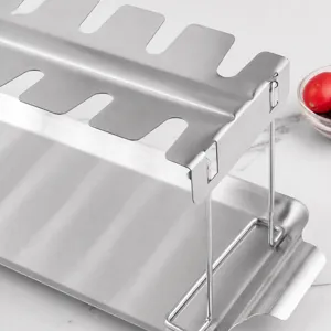 Stainless steel foldable chicken drumstick rack with drip tray for outdoor BBQ and roasting.