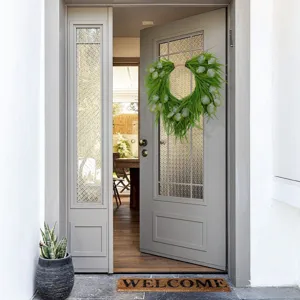 Detailed view of artificial green eucalyptus and pine wreath hanging on the door.