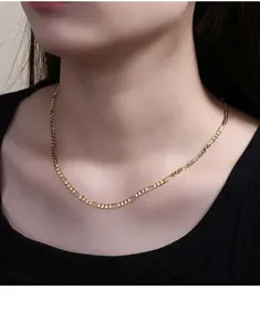 Primo piano dettagliato dell'elegante collana con catena Figaro dorata sul modello, maglie.