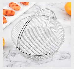 Stainless steel air fryer basket detail, round mesh steamer and cooling rack for kitchen cooking.