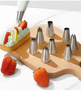 Detailansicht von Edelstahl Spritzbeutel Tüllen Set auf Holzbrett mit Kuchen und Beeren.