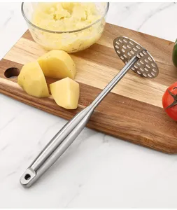 Vue détaillée du presse-purée en acier inoxydable montrant la plaque perforée robuste.