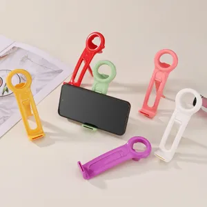 Pratico apribottiglie multifunzione in plastica colorata e supporto per telefono portatile.