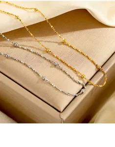 Detailaufnahme von filigranen Zwillings-Sternperlenketten, glänzendes Silber und Gold feine Ketten.