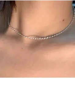 Detailopname van een S925 zilveren gedraaide ketting ketting elegant gedragen om de hals.