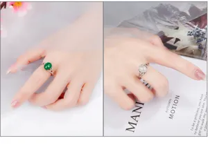 Detailansicht von S925 Silber grüne und weiße Jade Achat offene Ringe an der Hand getragen.