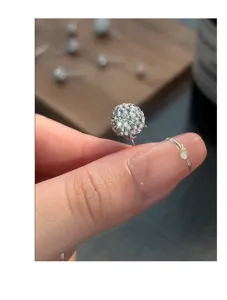 Wunderschöne s999 Silber Strass Kugel Ohrstecker Detailansicht auf dem Finger präsentiert.