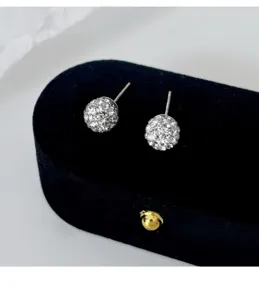 Detailaufnahme von glitzernden Kristall-Kugel-Ohrringen auf schwarzem Samt, elegant und fein.