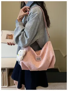 Dettaglio elegante borsa a tracolla rosa con stelle, look casual quotidiano con orsetto.