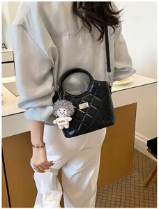 Sac à bandoulière matelassé noir chic pour femme, avec poignée supérieure et fermoir élégant.