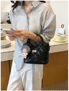 Vue détaillée d'un élégant sac à bandoulière rétro matelassé noir avec joli fermoir.