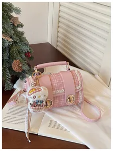 Pink tweed Boston handbag with lace trim, top handle, and cute plush cat keychain accessory.