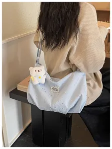 Vista dettagliata della borsa tote stellata dolce con ciondolo a orsetto, design a spalla casual.