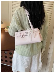 Sac à épaule chic en cuir rose avec boucle métallique et ravissant nœud en perles.