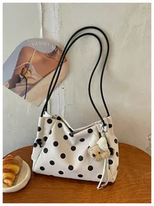 Detail view of the lazy style polka dot shoulder bag with thin straps and cute bear pendant.
