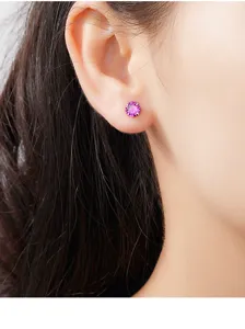 Nahaufnahme Detailansicht eines lila Zirkonia Ohrsteckers am Ohr, elegantes und schlichtes Design.