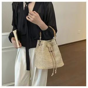 Élégant sac seau en paille avec poignée en bambou, idéal pour la plage et l'usage quotidien.