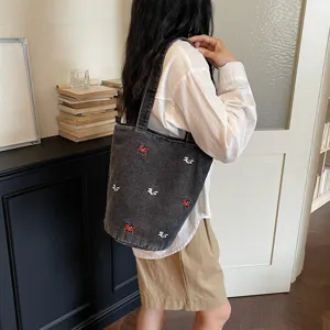 Borsa a secchiello casual in denim con dettagli ricamati eleganti per donne moderne.