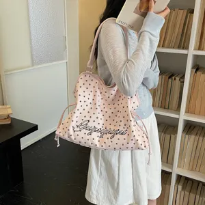 Vue detaillee d'un grand sac cabas epaule rose avec des motifs de pattes noires et texte.