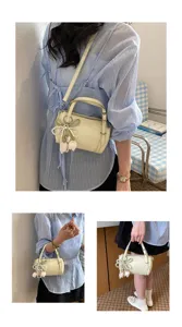 Chic light yellow pillow shoulder bag for women with elegant pearl tulip charm and strap.