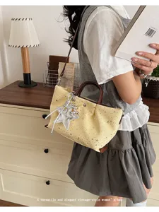 Detailed view of the yellow star tote bag with brown handles and a stylish silver star charm.