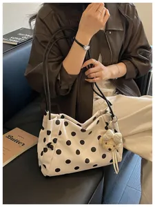Canvas polka dot shoulder bag detail, stylish commuter tote bag with cute bear charm for daily use.