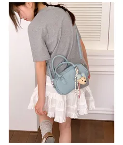 Trendy blue bowling shoulder bag for women, versatile crossbody purse with cute bear pendant.