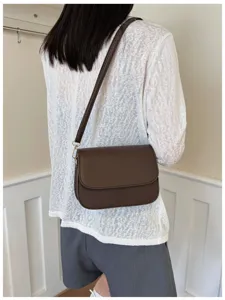 Detail shot showing the stylish dark brown shoulder bag worn on model, daily fashion chic.