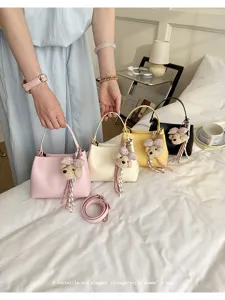 Versatile vintage women's shoulder handbag with cute bear pendant, stylish bucket bag style.