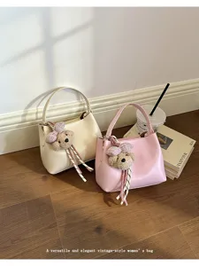 Versatile and elegant women's PU leather bucket bag with cute bear charm for daily commute.