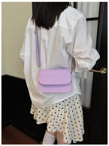 Detail view of the elegant light purple crossbody bag worn by model, simple design fashion.
