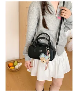 Black bowling shoulder bag, trendy commuter crossbody handbag with cute bear pendant for women.