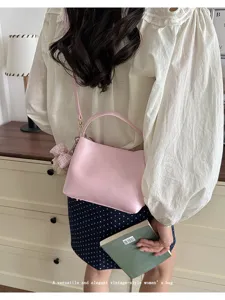 Pink bucket shoulder bag for women, elegant vintage PU leather handbag with cute charm.