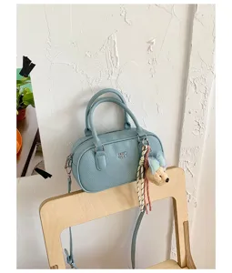 Casual blue bowling shoulder bag for women, stylish crossbody handbag with cute bear charm.
