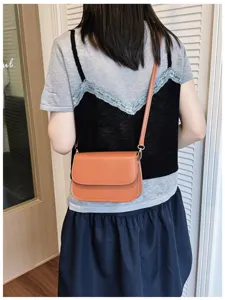 Back view detail of casual brown crossbody shoulder bag showing flap design and strap.