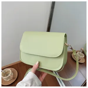 Close-up of minimalist light green crossbody bag featuring clean texture and hardware.