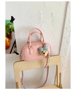 Pink bowling shoulder bag close-up detail, cute bear pendant, trendy PU leather handbag.