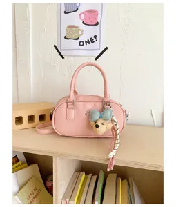 Pink women bowling shoulder bag, stylish commuter handbag, trendy versatile crossbody daily bag.