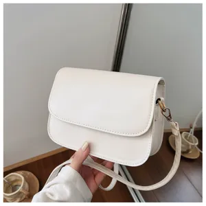 Detailed view of the white minimalist crossbody bag showing fine PU leather texture.