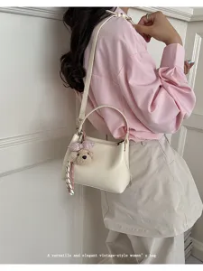 Elegant vintage-style women's shoulder bag with cute plush bear charm for daily commute.
