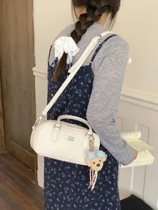 Chic white bowling shoulder bag for women, stylish crossbody purse with cute puppy charm.