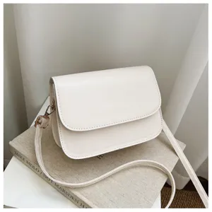 Minimalist white crossbody shoulder bag detail, sleek PU leather flap design, elegant style.