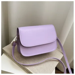 Detail shot of a simple purple PU leather crossbody bag, showcasing fine stitching and texture.