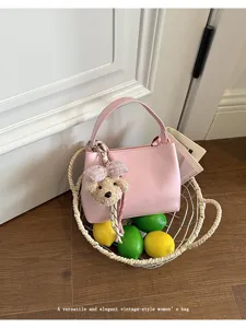Pink top-handle bag detail scene styled with lemons in a woven basket for summer chic look.