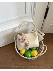 Details of the elegant beige women's handbag featuring a cute teddy bear charm and lemon decor.