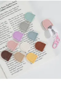 Detail view of colorful leather mini scissor sleeves and protective covers with clips.