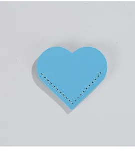 Close-up view of a blue leather heart-shaped corner bookmark with detailed stitching.