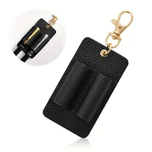 Detailed view of black leather double pen holder keychain with gold metal clasp, closeup shot.