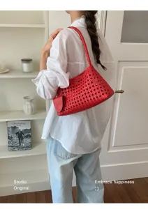 Détail de sac porté épaule en cuir tissé rouge, sac hobo élégant pour femmes avec design ajouré.